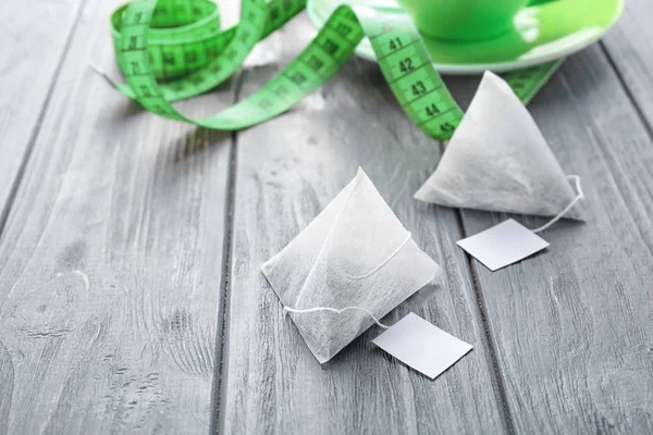 Teabags with leaves and measuring tape — Stock Photo, Image