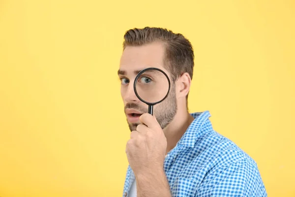 Handsome young man with magnifier — Stock Photo, Image