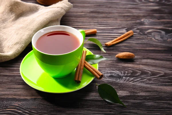 Tazza di delizioso tè e cannella in tavola — Foto Stock