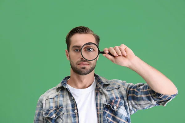 Handsome young man with magnifier — Stock Photo, Image