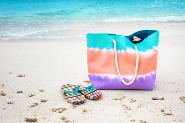 Bag and flip-flops on sea beach — Stock Photo, Image