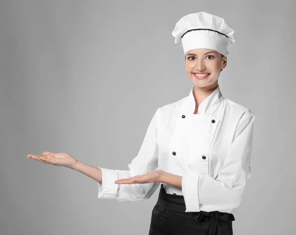 Junge Köchin auf hellem Hintergrund — Stockfoto