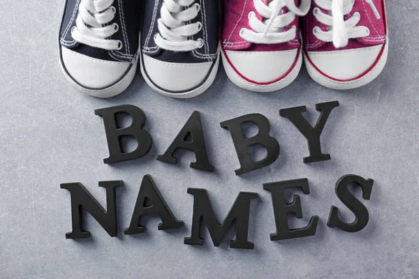 Text Baby jména a boty na šedém pozadí — Stock fotografie