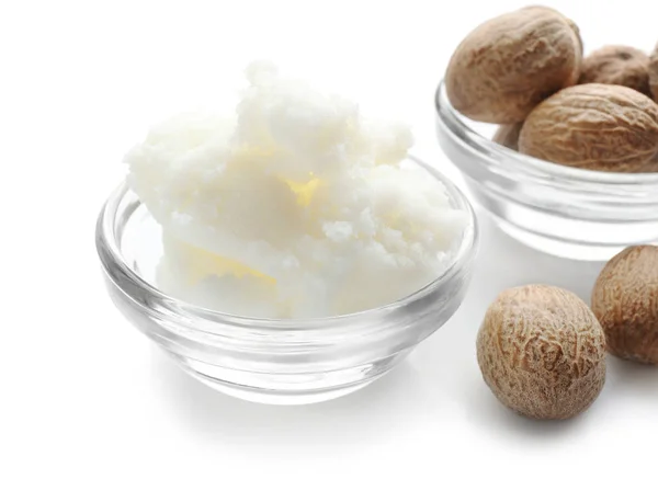 Shea butter and nuts in bowls — Stock Photo, Image