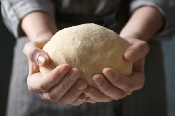 Woman holding raw dough in hands