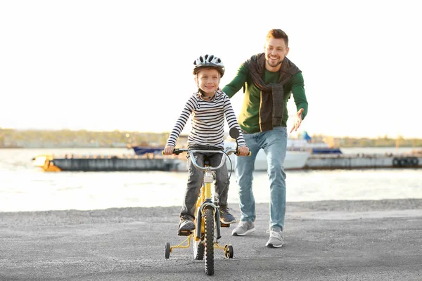 Dad teaching son to ride bicycle outdoors — Stock Photo, Image
