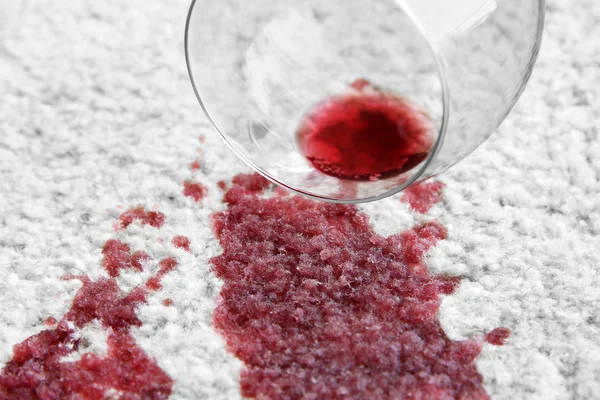 Glass of red wine spilled on carpet — Stock Photo, Image