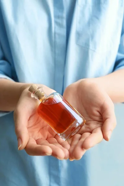 Woman holding vanilla extract in bottle — Stock Photo, Image