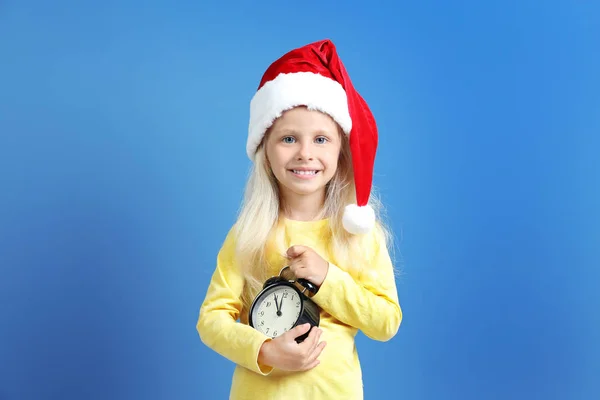 Petite fille mignonne dans le chapeau de Père Noël avec horloge — Photo