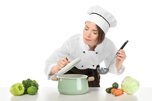 Vrouwelijke chef-kok met steelpan en fruit op witte achtergrond — Stockfoto