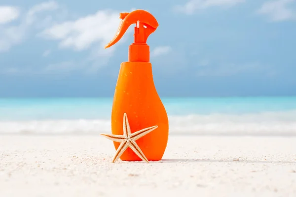Bottle with sunscreen cream and starfish — Stock Photo, Image