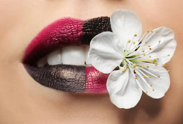 Lábios de mulher com maquiagem criativa e flor — Fotografia de Stock