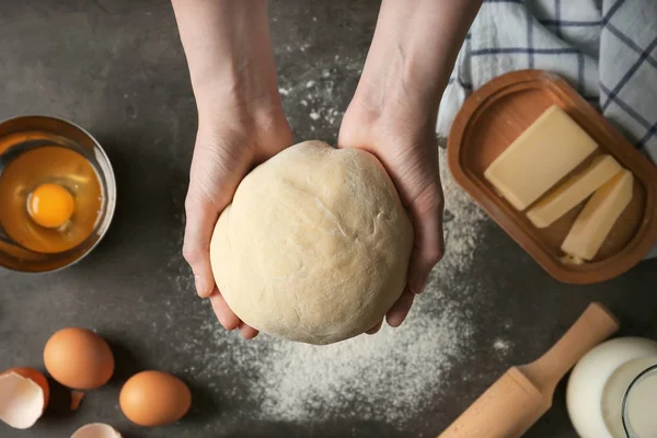 Woman holding raw dough in hands — Stock Photo, Image