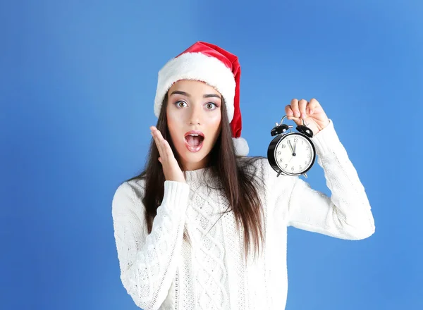 Jeune femme en chapeau de Père Noël avec horloge — Photo