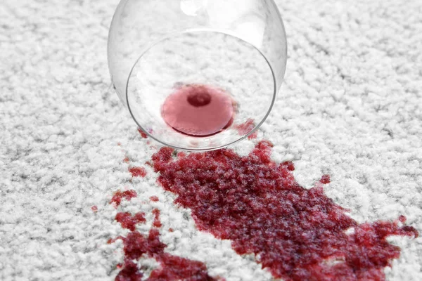 Copa de vino tinto derramada en la alfombra —  Fotos de Stock