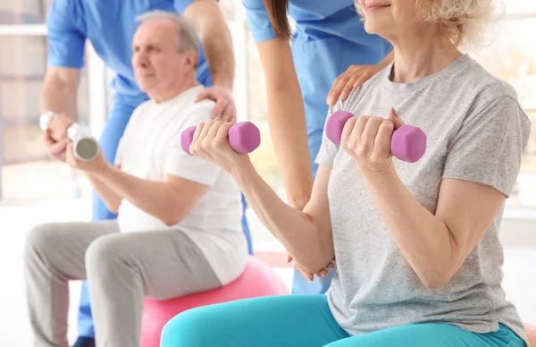 Oudere patiënten en fysiotherapeuten in moderne kliniek — Stockfoto