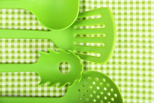 Vihreät astiat ginghamin tekstiilitaustalla — kuvapankkivalokuva