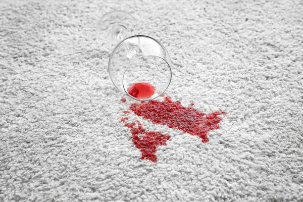 Copo de vinho tinto derramado no tapete — Fotografia de Stock