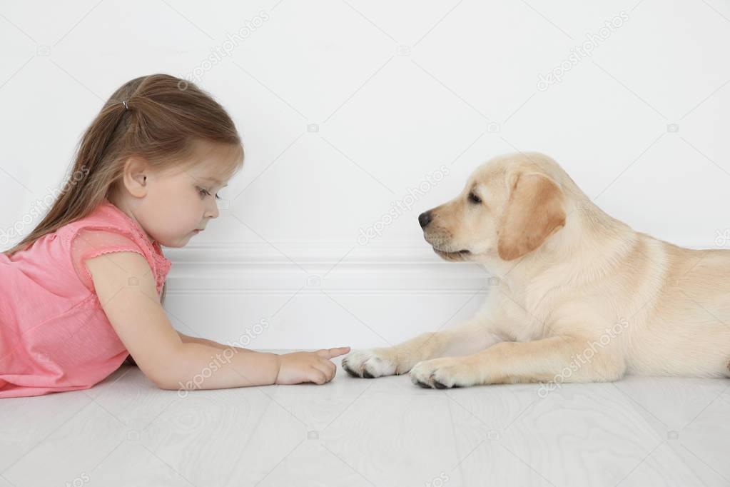 Cute child with Labrador Retriever at home