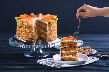 Genç kadın havuçlu kek masada tatma