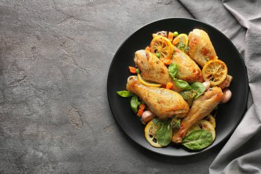 Plate with delicious roasted chicken drumsticks  clipart
