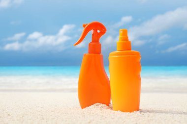 Deniz kıyısında güneş koruyucu krem ile şişe