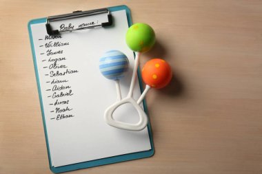 Bebek isimleri ve rattle ahşap arka plan üzerinde listesi