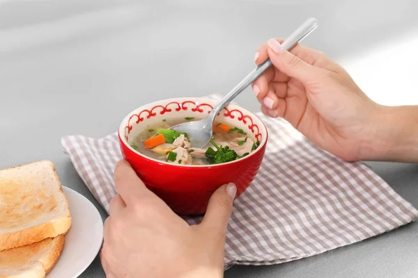 Mujer comiendo sopa de pollo casera en la mesa — Foto de Stock