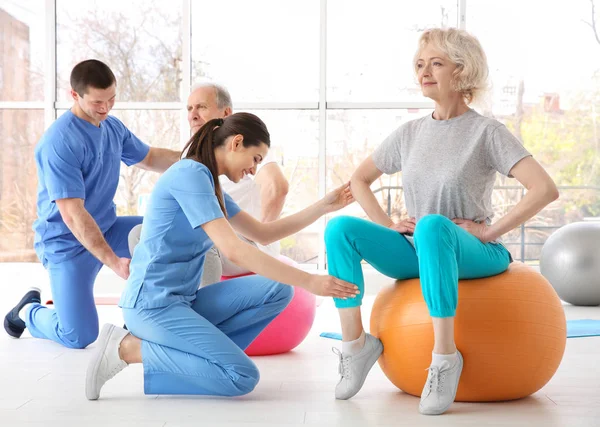 Idős betegek modern klinikán dolgozó gyógytornászok — Stock Fotó