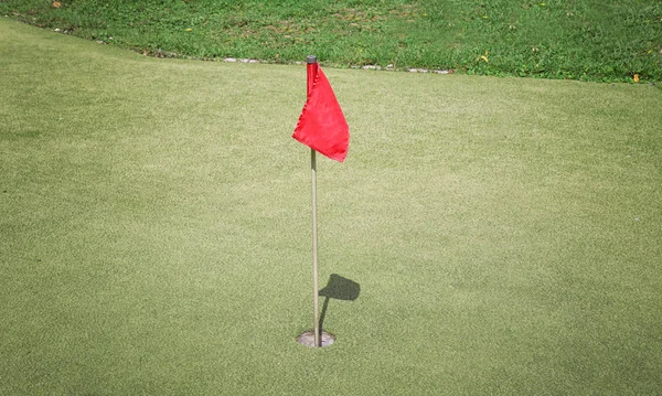 Flag and hole on golf course — Stock Photo, Image