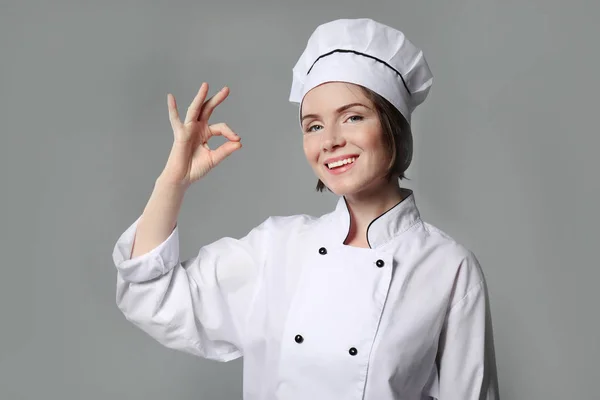 Chef feminino em fundo cinza — Fotografia de Stock