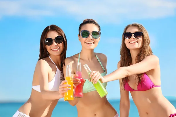 Belles jeunes femmes en bikini avec boissons alcoolisées en station balnéaire — Photo