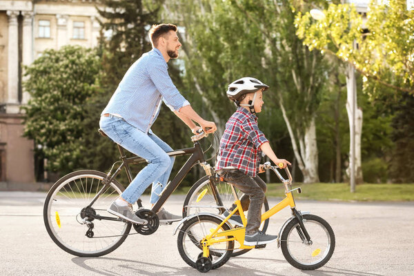 Dad and son riding bicycles outdoors