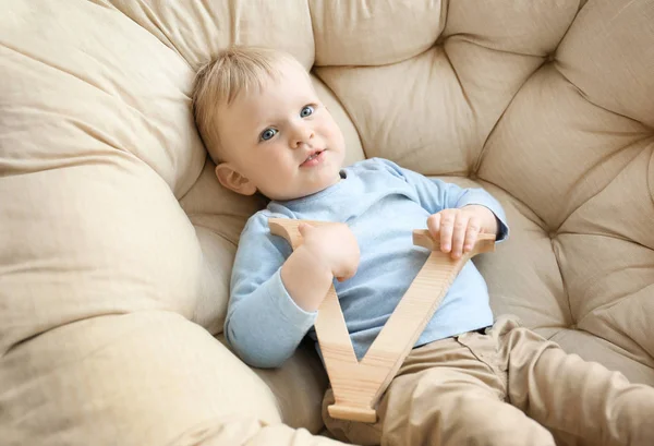 Schattige kleine jongen met de letter V in leunstoel — Stockfoto