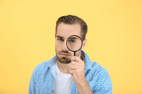 Handsome young man with magnifier — Stock Photo, Image