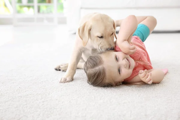 Schattig kind met Labrador Retriever thuis — Stockfoto