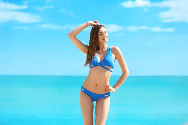 Hermosa joven en bikini cerca del mar en el día de verano —  Fotos de Stock