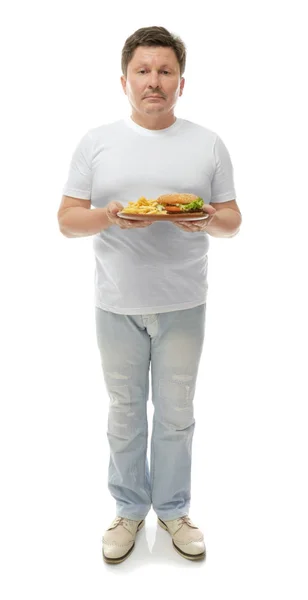 Przytrzymanie płyta z śmieciowe jedzenie na białym tle nadwaga człowieka. Koncepcja utraty wagi — Zdjęcie stockowe