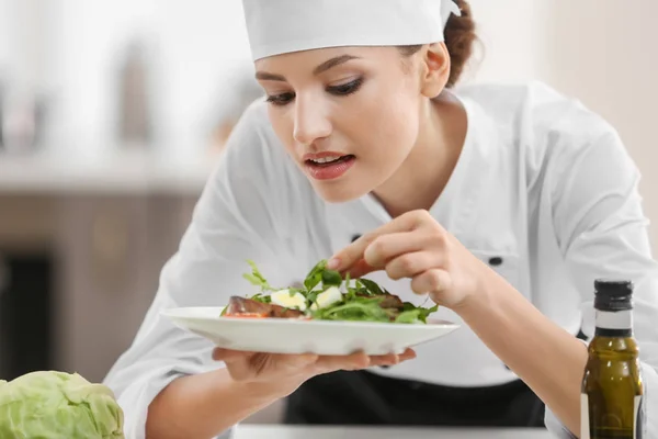 Jonge vrouwelijke chef-kok met smakelijk gerecht in keuken — Stockfoto