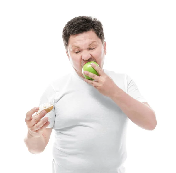 Överviktig man med apple och donut på vit bakgrund. Kost-konceptet — Stockfoto