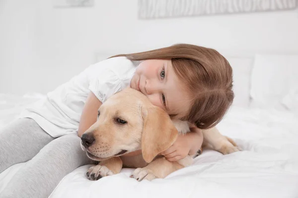 Schattig kind met Labrador Retriever op bed — Stockfoto