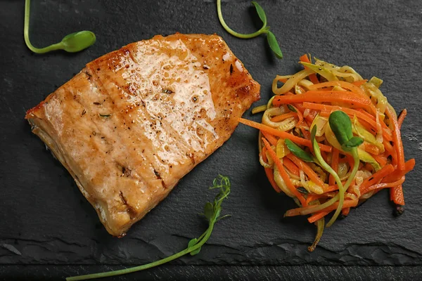 Filete de pescado y verduras en plato de pizarra —  Fotos de Stock