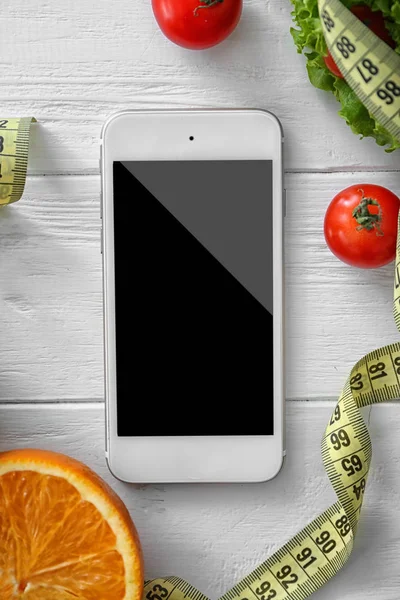 Мобильный телефон со здоровой свежей пищей — стоковое фото