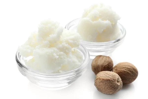 Shea butter in bowls and nuts — Stock Photo, Image