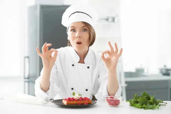 Kvinnlig kock med läckra efterrätt i köket — Stockfoto