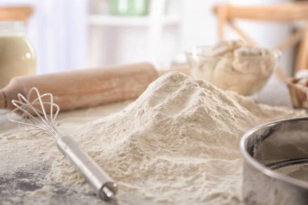 Flour and whisk on kitchen table — Stock Photo, Image