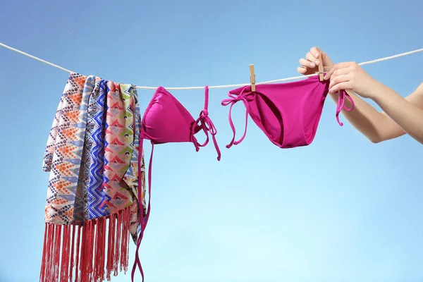 Manos colgando ropa de playa en línea — Foto de Stock