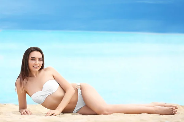 Hermosa joven en bikini en la playa de mar — Foto de Stock