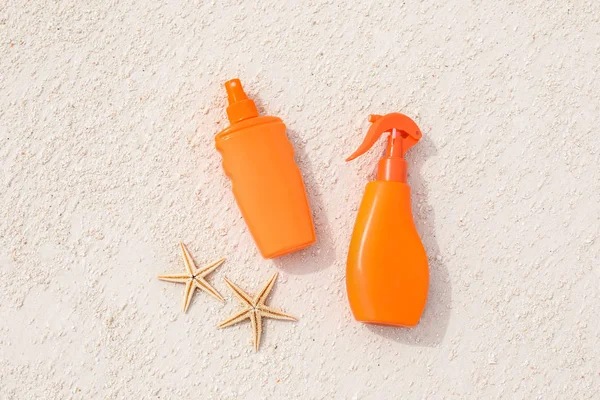 Bottles with sunscreen cream and starfish — Stock Photo, Image