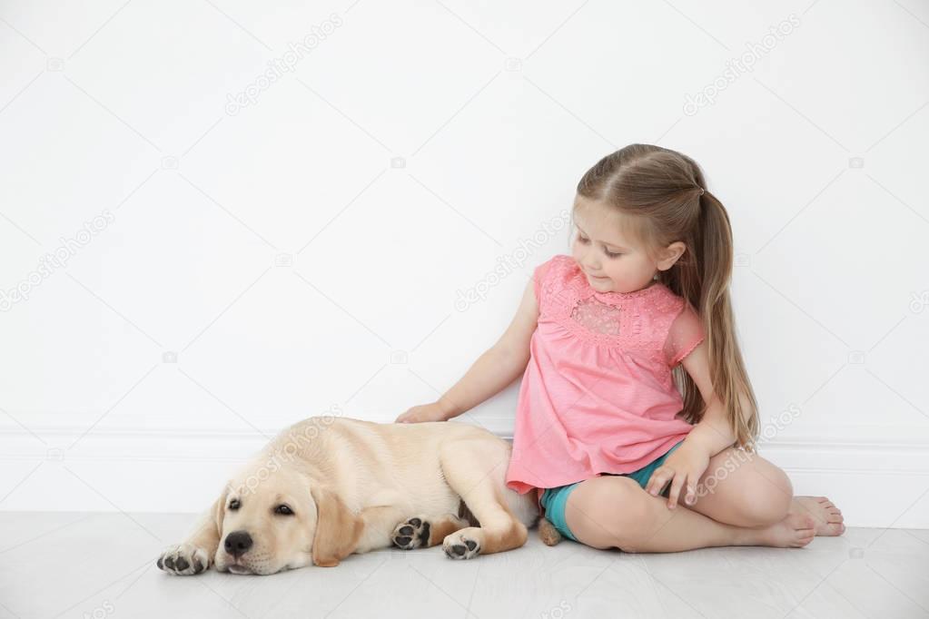 Cute child with Labrador Retriever at home